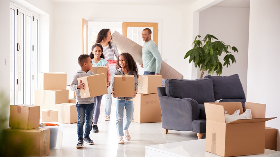 family-carrying-boxes-into-new-home