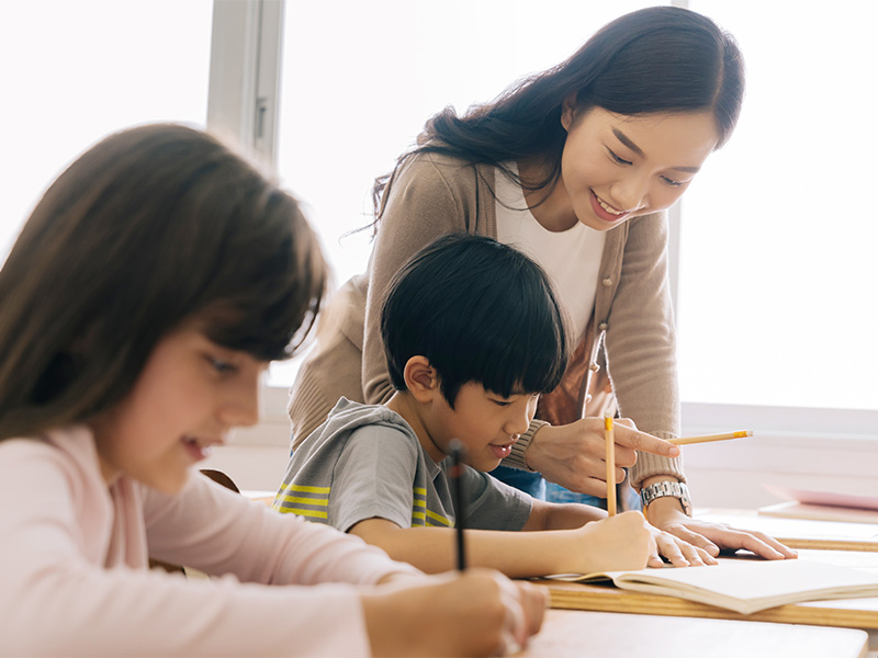 teacher-reads-students-writing-over-shoulder-4-3